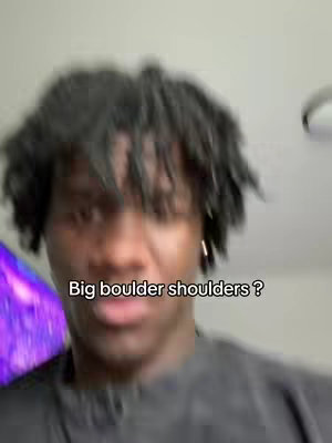 A selfie-style video cover, the person is shown from the chest up and is slightly blurry. The man looks directly into the viewer with a questioning expression or furrowed brow. The background is blurred, but the person has a dark complexion and black, somewhat messy hair is a key element.