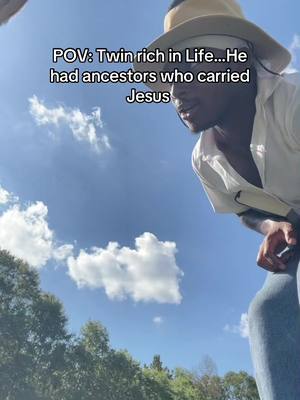 A man wearing a hat and white shirt is looking down toward the ground, framed against a bright blue sky with scattered white clouds. Trees are visible at the bottom of the frame, and text overlays the image, describing a point of view (POV).