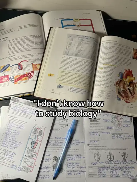 The image is a top-down shot of a desk covered in open books and handwritten notes. The books are educational, with diagrams and text visible, hinting at biology studies. A pen lies across the notes, and there is a text overlay. The color palette is muted with white, tan, black, and blue tones.