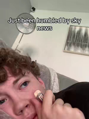 A young man lies, with a cosmetic brush near his face. The cover art features text overlayed on the image.