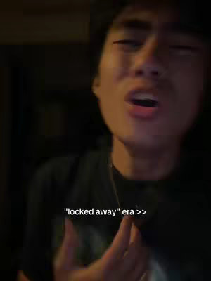 The cover image features a person facing the camera in close up with the mouth open. The background is in a dark setting. The text overlay reads "locked away" era >>, in white font.