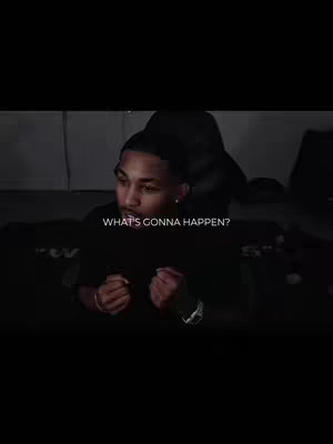 A man in a black shirt is looking down with a serious expression. Text overlay 'WHAT'S GONNA HAPPEN?' in white font. The background is dark, creating a focused atmosphere.