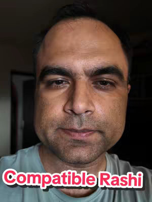 A close-up selfie featuring a man with a fair complexion and short dark hair. He has a neutral expression with his face framed by a slightly out-of-focus background. Overlayed on the image is a text box that says 'Compatible Rashi' in a playful font with a white border.