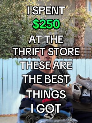 A man holds items he bought from a thrift store, with text overlayed. The man is standing outside near foliage and a blue fence. The text overlay lists the amount spent and what's in the bags.