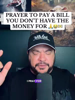 The image features a man with a beard wearing a black cap with the words "With God" on it and closes his eyes. Above the man's head, there's a text overlay in a white box, reading "PRAYER TO PAY A BILL YOU DON'T HAVE THE MONEY FOR".