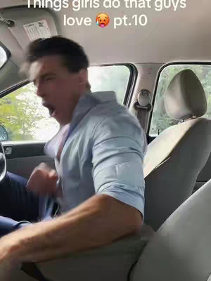 A man inside a car, exclaiming with his mouth wide open. The setting appears to be a car interior with the seat, steering wheel, and a portion of the open window visible. The man wears a light-blue button-down shirt, and his sleeves are rolled up. The text overlay is positioned at the top, reading 'Things girls do that guys love pt.10'.
