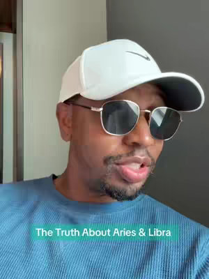 A man wearing a white Nike baseball cap and sunglasses is the primary subject of the image set against a neutral background and soft lighting; he's wearing a blue t-shirt focusing the composition towards his face and upper body while a light teal text overlay is visible.