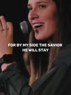 The cover image shows a woman singing into a microphone. The background is dark, and the woman is wearing a dark-colored top. Text overlayed on the image reads, "FOR BY MY SIDE THE SAVIOR HE WILL STAY." The overall composition is focused on the woman's face and upper body with a blurred background.