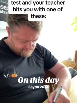 A man with a beard and a black t-shirt is writing with a pen. Text overlays are present, including a humorous quote and the date.