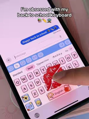 The cover image shows a phone screen displaying a custom keyboard with a pink and white color scheme. The keyboard has a 'back to school' theme, featuring school-related emojis. A finger with red lipstick is pressing the 'U' key. Text overlays include the hook and a message bubble stating 'Happy back to school'.