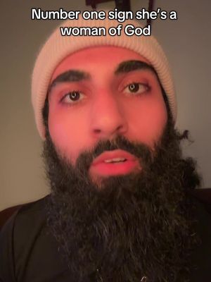 The image features a close-up shot of a man with a beard and a beanie. Above his head is the text "Number one sign she's a woman of God."