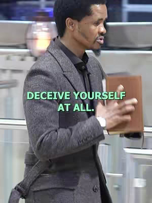 A man in a gray coat is holding a brown book in front of a blurred background. Text overlayed in green.