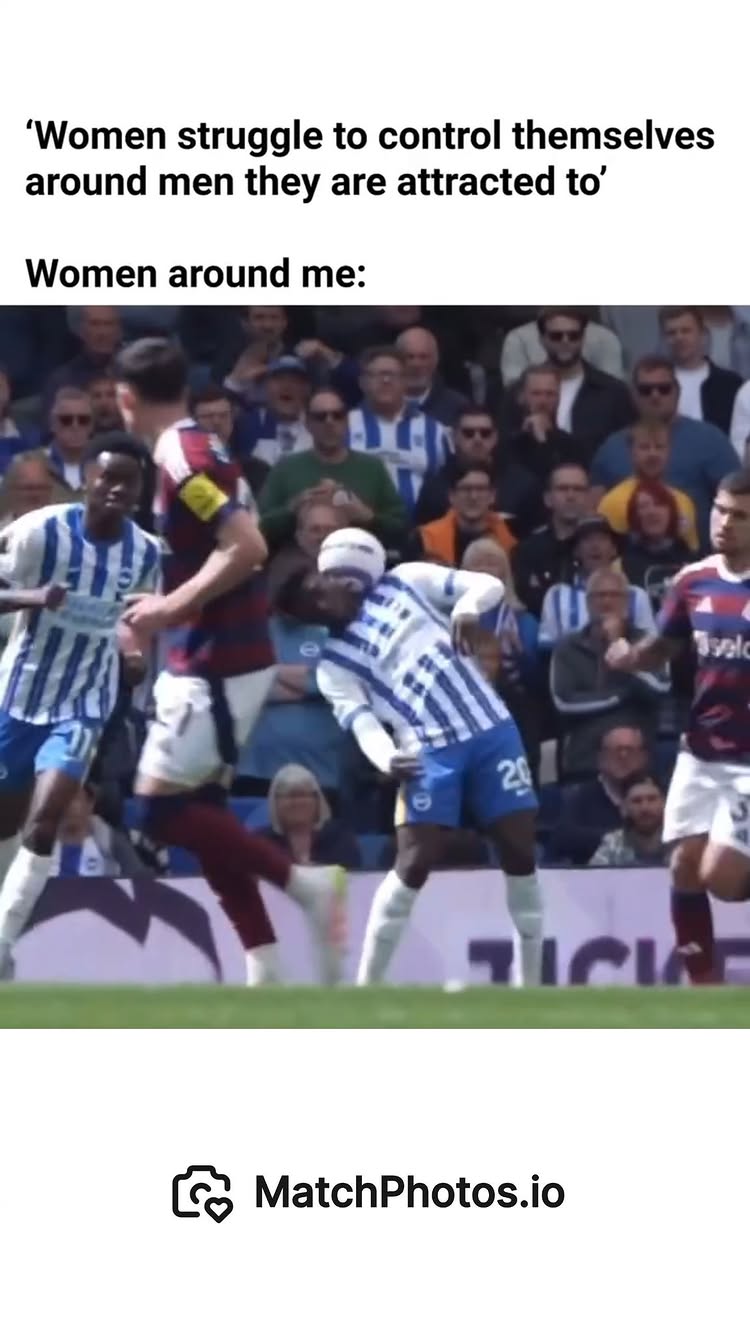 The image shows a soccer match with multiple players in motion and a crowd of spectators in the background. The main focus is on the players in their uniforms, capturing a moment of action. The color palette is natural with the green of the field contrasting with the varied colors of the uniforms and the crowd's attire.
