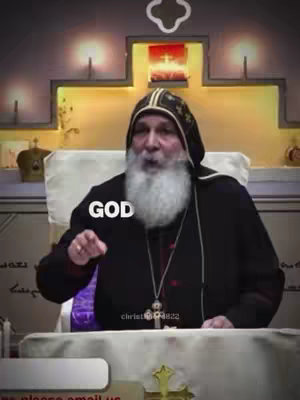 The cover image features an older man with a white beard wearing a black religious garment, set indoors. The background includes a decorative wall with illuminated alcoves and a cross, creating a solemn setting. The man is making a gesture, with text 'GOD' overlaid.
