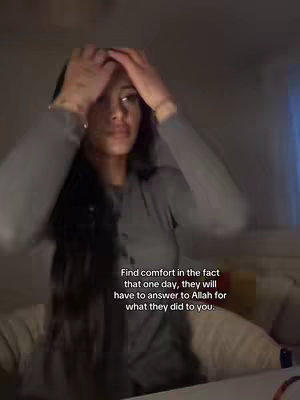 A woman with long dark hair holds her hands near her head in front of a dimly lit background. Overlayed text provides a motivational message.