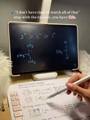 A person is studying, represented by a tablet with handwritten notes and equations on it in the foreground. A piece of a keyboard and other notes are also visible below. The hook text is at the top-left corner of the image. The background is blurry.