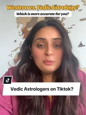 A woman with long dark hair faces the camera directly. She wears a pink top, and the background reveals a wooden world map and a light-colored wall. Text overlays include a title at the top in a yellow box and a question, and another label at the bottom in a white background, indicating the video is related to Vedic astrology and TikTok.