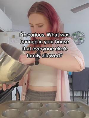 A woman with red hair stands in a kitchen, holding a mixing bowl and looking down. The image is brightly lit, with a text overlay in white lettering.