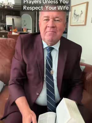 A middle-aged man in a burgundy blazer and a striped tie sits on a brown leather sofa, holding a book or bible. Text overlayed on the top suggests a religious or motivational theme related to prayer and respect within marriage.