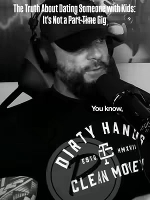 The cover image is a grayscale shot featuring a man, likely seated, with a microphone close to his face. He's wearing a baseball cap and headphones, suggesting a podcast or recording setup. His attire includes a t-shirt with a circular logo featuring text. The overall composition has a close-up perspective, focusing on his face and upper body.
