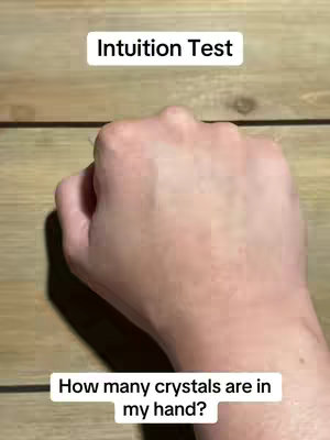 The image presents a hand with the fist closed. Overlaid text provides context to the image. The background utilizes a close-up view of light-brown wooden planks.
