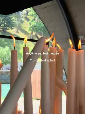 A view of lit candles with flames against a backdrop of a window showing trees. Text is superimposed on the image.