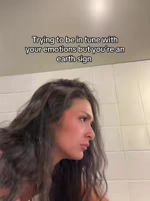 The cover shows a woman in profile, looking slightly off-camera with a thoughtful expression. She has long, wavy hair and is in a bathroom setting. The background appears to be white tiled walls. Text overlayed across the top of the image.