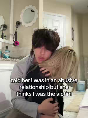 A young man is embracing another person, whose face isn't visible, in a bathroom setting. Text overlay on the image conveys a story about an abusive relationship.
