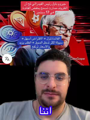The cover image shows a man in a selfie-style video. Behind him, there are graphics showing cryptocurrency logos alongside an image of Jerome Powell, the Federal Reserve Chairman. Text overlays in Arabic provide market commentary and financial analysis. The overall composition uses a combination of overlaid text, images, and the creator's face to convey financial news.
