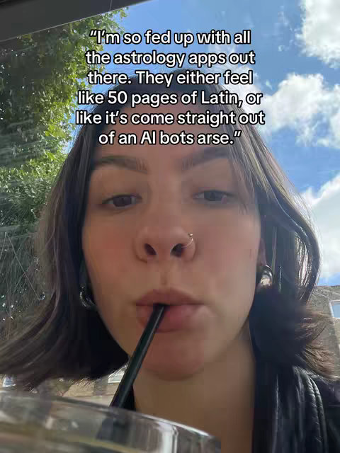 A selfie of a woman with brown hair taking a drink through a black straw. The image is framed from the chest up, with text overlaid at the top. She has a nose ring and hoop earrings. Behind her is a bright sky with a few clouds.
