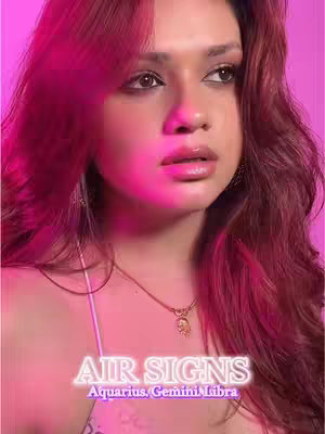 A selfie-style shot featuring a young woman with long red-brown hair and full lips. She is positioned against a softly lit pink background, with text overlayed at the bottom of the frame. The woman wears a casual top and a delicate necklace. The lighting emphasizes her facial features, highlighting her eyes and smooth skin.