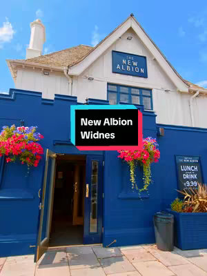 The cover image is a daytime shot of a building. The building is painted blue, and has a white upper structure. The building has a sign that says "The New Albion" on it. There is text that overlays the image that says "New Albion Widnes".