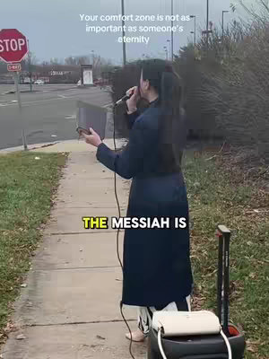 A person stands on a sidewalk holding a microphone and a tablet, with a stop sign and street in the background. Text overlays the image, and a rolling cart is positioned to the right.