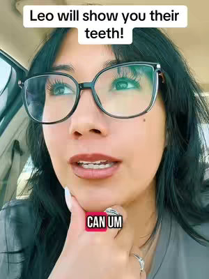 A woman with black-framed glasses looks to the side while talking. The background appears to be inside a car. Text overlays are present at the top and bottom of the frame.