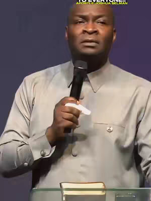 A man wearing a light gray shirt and a microphone is holding a white tissue. Text at the top says 'TO EVERYONE!! Apostle Joshua Selman'. The man is standing in front of a dark purple background with a podium in front of him that has a book on top.