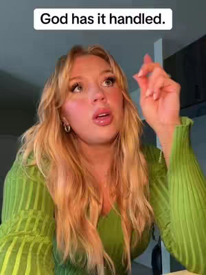 A woman with long blonde hair and a green top looks up with an open mouth, one hand raised in a gesture. Text overlayed on top reads, "God has it handled."