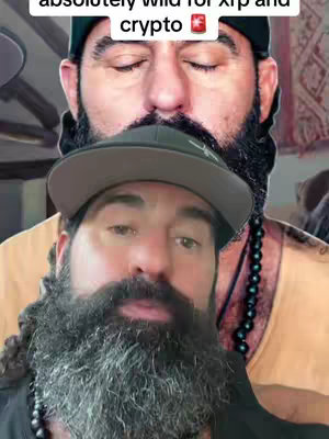 The cover image is a selfie-style shot featuring two men, one positioned behind the other. The foreground shows a man with a full, gray beard, wearing a dark hat and a black shirt. The man behind him has a black hat and eyes closed. The background is blurred, suggesting an indoor setting with muted colors.
