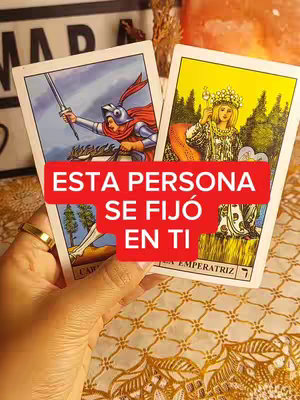 A hand holds tarot cards, The red text overlay says 'ESTA PERSONA SE FIJÓ EN TI' over the cards. The cards are the Knight of Swords and The Empress.