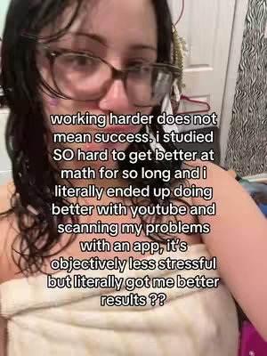 A selfie-style video cover with a woman. She has fair skin, dark hair, and glasses. The background seems to be a bathroom setting with visible toiletries. The overlay text explains how the creator got better grades.