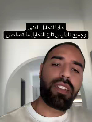 A selfie-style shot featuring a man with a beard in a well-lit hallway, with text over his head. He is directly addressing the camera and seems to be speaking.