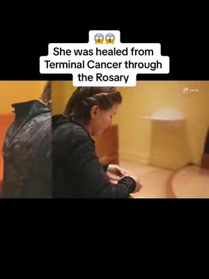 The cover image shows a split screen. On the left, a dark-clad figure, partially visible, represents an unseen person. The right side presents a woman in dark clothing looking down, with a part of a blurred background visible. A text overlay in a white rectangle at the top reads, "She was healed from Terminal Cancer through the Rosary".