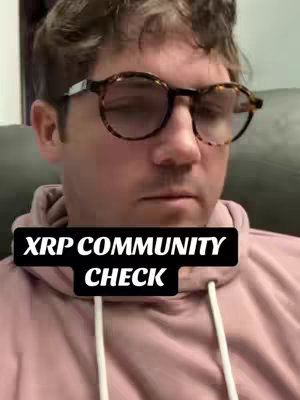 A medium shot shows a man with short brown hair and glasses. He's wearing a pink hoodie and looking down, with a black rectangle overlayed on him with text, the background is a blurry interior shot.