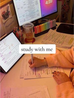 The cover image showcases a study setup with a white table and a person's hands writing on paper. A laptop and a tablet with diagrams of molecules are visible, and a monitor displaying a calendar is also on the table. The scene is well-lit, with papers, colorful markers, and a clear cup of liquid.