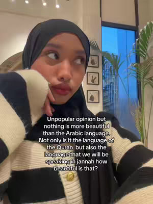 The cover image features a close-up of a young woman, presumably the creator, sitting in front of a window with a neutral expression. She's wearing a black hijab and a cream-colored sweater with black stripes. Text, written in English, appears above the creator's head discussing Arabic language and its beauty. The layout is simple, focusing on the creator and the text overlay.