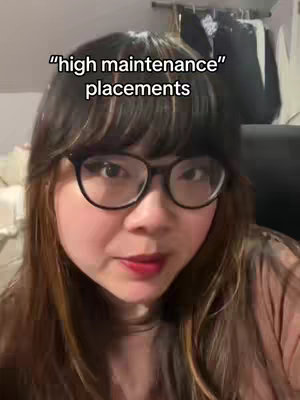 A woman with long dark hair and glasses is centered in the frame. Overlaid on the image is text in white, and the background appears to be indoors, possibly a bedroom.