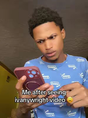 A young man with dark, tightly curled hair looks at his phone with a concerned expression. He is wearing a blue shirt with a white pattern, holding the phone with one hand and gesturing with the other. Text overlays on top of the image.