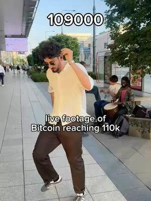 The cover image shows a man in a white shirt, black pants, and sunglasses dancing on a city sidewalk. Text overlays include '109000' and 'live footage of Bitcoin reaching 110k'. In the background, people are sitting on a bench with a drummer. The setting appears to be an outdoor urban area. The image is well-lit, capturing a moment of movement and excitement.