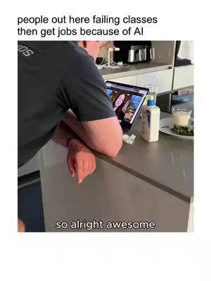A man leans on a countertop in a kitchen. Behind him, a laptop displays a video, and on the counter are items like a bottle of lotion and a glass of liquid. Text overlays the image stating 'people out here failing classes then get jobs because of AI' and 'so alright awesome'.