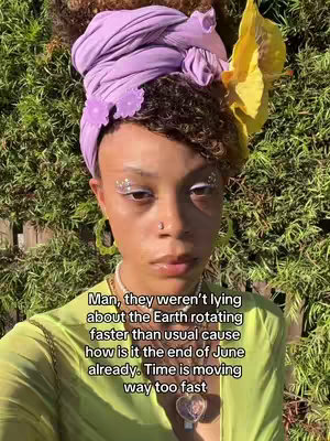 A person dressed in a light yellow top with a vibrant purple head wrap and a yellow flower accent. They have silver glitter makeup around their eyes and a necklace with a heart pendant. Text overlay details the rapid passage of time.