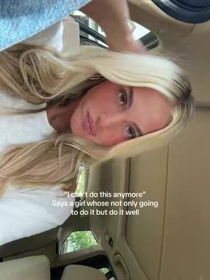 A selfie-style shot of a woman with blonde hair inside of a vehicle. The shot is taken from a low angle, looking up, and the woman's face and upper body take up a large portion of the frame. The background reveals a car ceiling, a car window and the outdoors. Above, her arm gestures toward her hair. Text is overlaid at the bottom, with a quote and a statement.